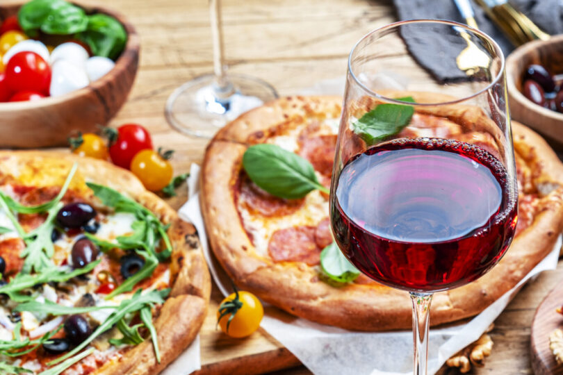 Pizza party dinner table. Glasses with red wine and plates, rust Kombinacije vina i testa koje mogu unaprediti vaše uživanje!